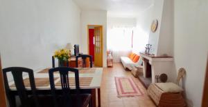 ein Wohnzimmer mit einem Tisch und einem Esszimmer in der Unterkunft Casa dos Buizinhos in Porto Covo
