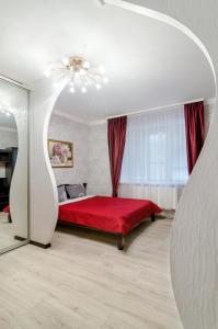 1 dormitorio con cama roja y manta roja en Good Home en Sumy
