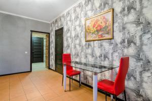 uma sala de jantar com uma mesa de vidro e cadeiras vermelhas em Good Home em Sumy