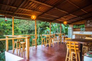 un bar con taburetes de madera y mesas en un restaurante en Masaya Casas Viejas, en Minca