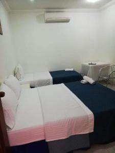 two beds sitting next to each other in a room at Gran Hotel Valvanera Girardot in Girardot