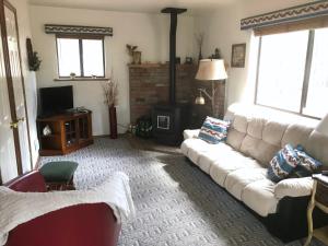 ein Wohnzimmer mit einer weißen Couch und einem Kamin in der Unterkunft Grand Canyon Cottage at Historic Wrigley Ranch with Horseback Riding & Shooting in Parks