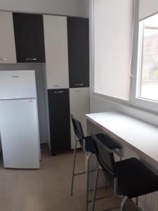 een kantoor met 2 stoelen, een bureau en een koelkast bij Luxury 1 Bedroom Apartment in Roşu