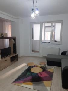 een woonkamer met een bank en 2 tafels bij Luxury 1 Bedroom Apartment in Roşu