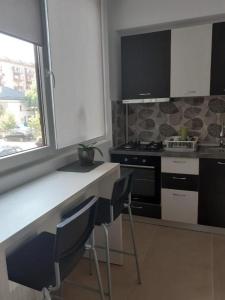 een keuken met een aanrecht, stoelen en een fornuis bij Luxury 1 Bedroom Apartment in Roşu