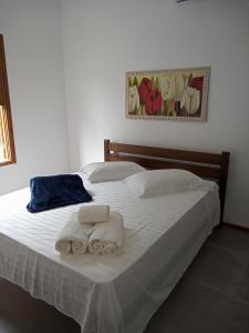 een slaapkamer met een bed met twee handdoeken erop bij Pousada Cipó Paraty in Paraty