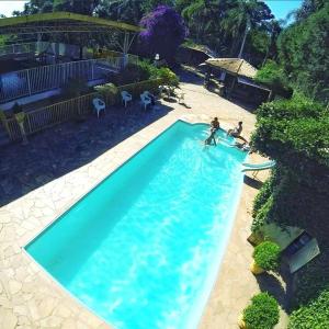 due persone che giocano in acqua in piscina di Sítio do Jota - Conforto e Natureza completo SP - km 54 Castelo Branco a San Paolo