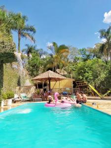un gruppo di persone in piscina presso un resort di Sítio do Jota - Conforto e Natureza completo SP - km 54 Castelo Branco a San Paolo