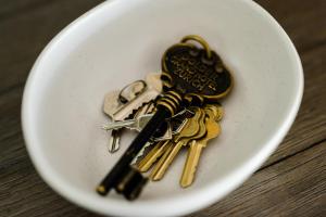 Ein paar Schlüssel in einer weißen Schüssel auf einem Tisch. in der Unterkunft Walnut Tree Cottages in Whorouly