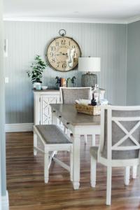 une salle à manger avec une table, des chaises et une horloge dans l'établissement Walnut Tree Cottages, à Whorouly