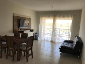een woonkamer met een tafel en stoelen en een televisie bij Villa das aguas-Praia do Saco-Proximo as lagoas dos Tambaquis e Mangue Seco in Praia do Saco