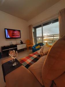 uma sala de estar com um sofá e uma TV em ZEUS - MODERNO COM WIFI, melhor Localização,máx 4 em São Carlos