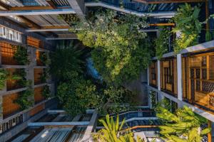 an indoor garden with benches and plants on a wall at Minh Boutique in Danang