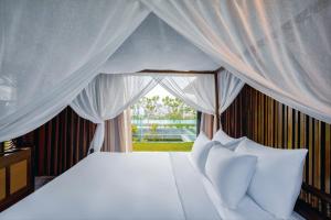 a bedroom with a white bed with a window at Minh Boutique in Danang