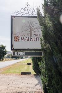 ein Schild für ein Walnussbaum-Schild auf einer Straße in der Unterkunft Walnut Tree Cottages in Whorouly