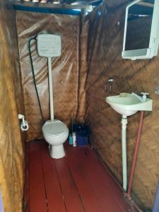 a bathroom with a toilet and a sink at Ajo Aloha Hostel in Cabo Polonio