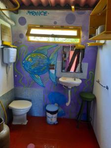 une salle de bains avec une peinture de poisson sur le mur. dans l'établissement Ajo Aloha Hostel, à Cabo Polonio