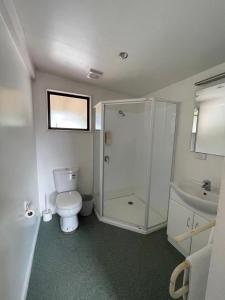 e bagno con servizi igienici, doccia e lavandino. di Blenheim Road Motor Lodge a Christchurch