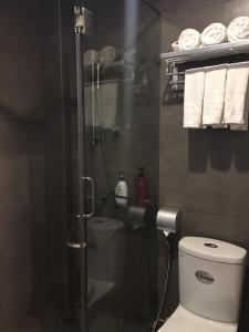 a bathroom with a shower with a toilet and towels at A25 Hotel - 66 Trần Thái Tông in Hanoi