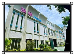 un grande edificio bianco con un cartello hotel sopra di 浪琴Motel文創旅館 a Taichung