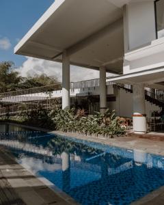 a swimming pool in front of a building at Rayz UMM Hotel Malang in Malang