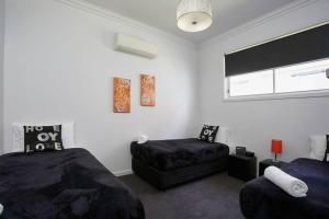 een slaapkamer met 2 bedden, een stoel en een raam bij 2easy on Chapel in Bendigo