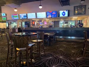 a bar in a restaurant with tables and televisions at Prospect Hotel Motel in Blacktown