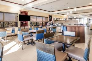 a restaurant with tables and chairs and a bar at Comfort Suites in Fort Stockton