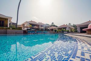 a large swimming pool with blue tiles on it at The Grand Leoney Resort in Vagator