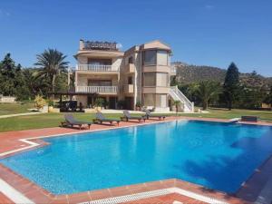 a large swimming pool in front of a house at Hellenic Hospitality Salamina in Panayía