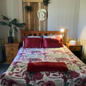a bedroom with a bed with a floral comforter at Corella Creek Country Farm Stay in Nelia