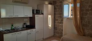 a kitchen with white cabinets and a sink and a window at Apartments Beba- Apartment Lucica in Komiža