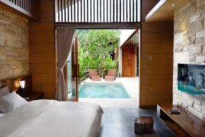 クタにあるBatatu Resort - Adults Onlyのベッドルーム1室(ベッド1台付)、スイミングプールが備わります。
