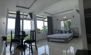 a bedroom with a bed and a table and chairs at Raveendra Inn in Kalpetta