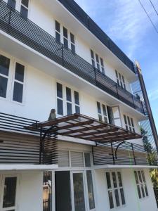 un uomo seduto su un balcone di un edificio di Raveendra Inn a Kalpetta Altre 12 foto