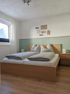 a bedroom with a large bed with white pillows at Tiroler Bergnestl in Imst