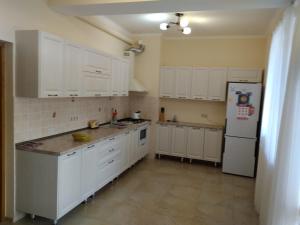 エストサドクにあるMargarita Guest Houseのキッチン(白いキャビネット、白い冷蔵庫付)