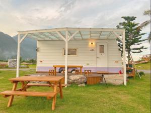 a picnic table and a tent with a table and benches at 崇霖覓境-花蓮崇德瑩農場 in Chongde