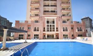 a swimming pool in front of a building at KeyHost - Minimalist 1BR - Dubai Sports City - K1020 in Dubai