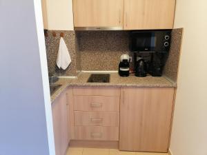a small kitchen with a stove and a microwave at Borovets Gardens Studio D36 in Borovets