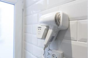 a hairdryer hanging on a wall in a bathroom at NEAR EIFFEL TOWER - BEAUTiFUL FLAT in Paris