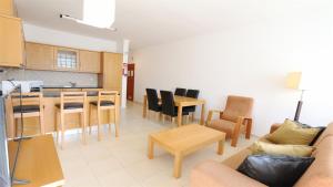 a living room with a couch and chairs and a kitchen at Terraços do Mar - Clever Details in Vilamoura