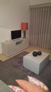 sala de estar con TV y mesa en Apartamento luminoso Urb. Quinta das Palmeiras en Porches