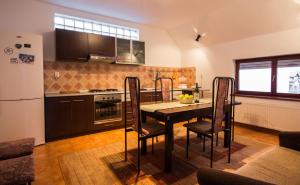 a kitchen with a table with chairs and a refrigerator at Villa Townhouse 36 Sibiu in Sibiu