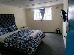 een slaapkamer met een bed en een raam bij MJ ACCOMODATION in Kaapstad