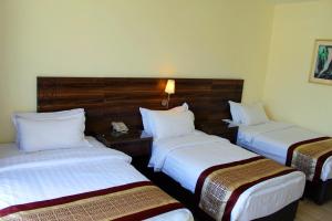 a hotel room with two beds and a telephone at Lacosta Hotel in Aqaba