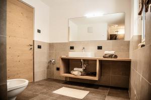 a bathroom with a sink and a toilet and a mirror at Willmüllerhof in Perca