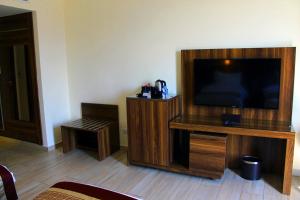 a living room with a flat screen tv on a wooden stand at Lacosta Hotel in Aqaba