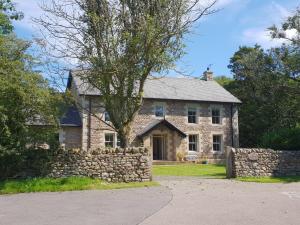 an old stone house with a stone wall at Anneside in Carnforth