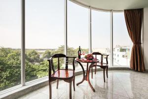 - une salle à manger avec une table, des chaises et de grandes fenêtres dans l'établissement Venus Hotel, à Hô-Chi-Minh-Ville